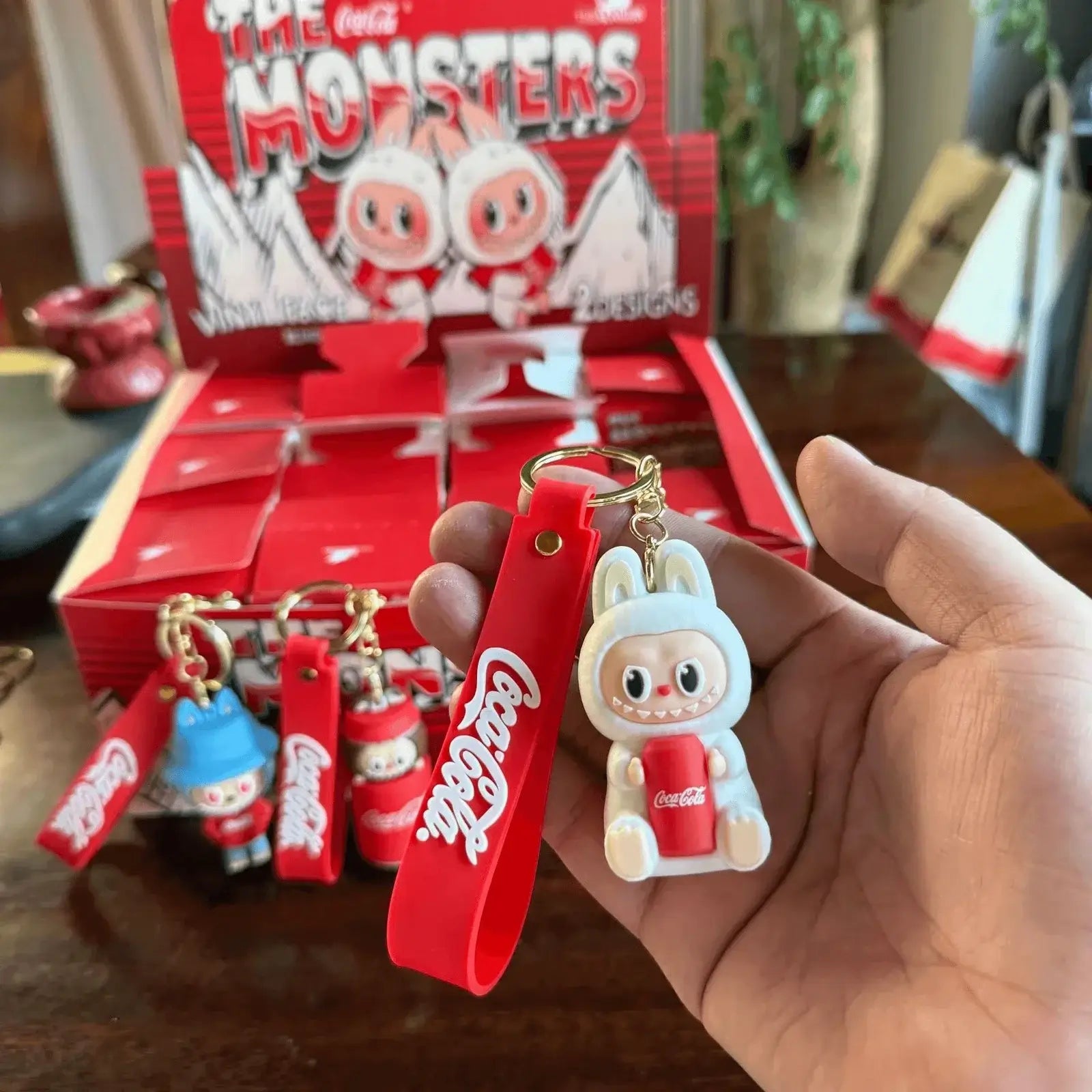 Porte-clés Labubu Coca-Cola collector présenté en main, accessoire kawaii inspiré de l'univers Coca-Cola.