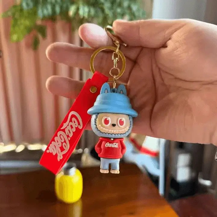 Figurine Labubu Coca-Cola dans sa caisse collector rouge, personnage adorable issu d'une édition spéciale de collection.